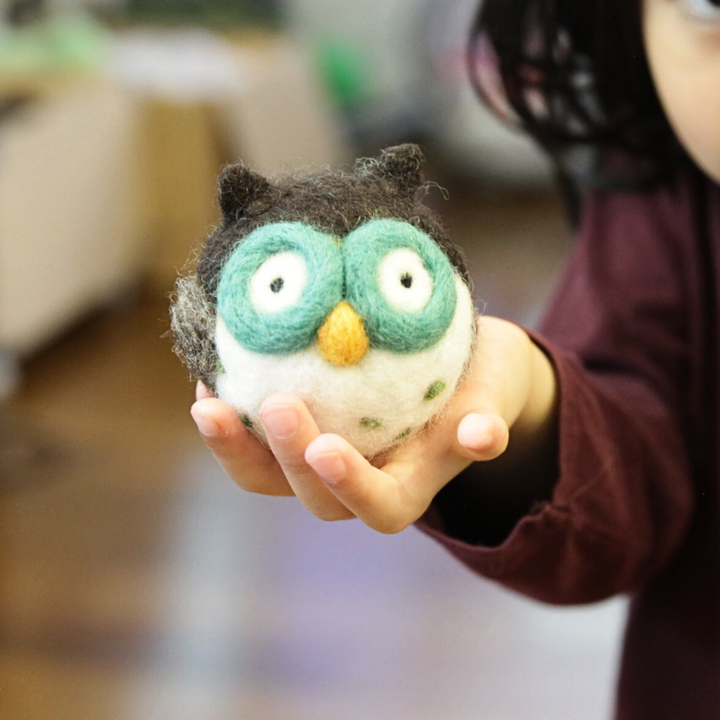 felted owl held by a child
